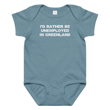 "I'd rather be unemployed in greenland" printed on a vintage indigo baby jersey bodysuit laying on a flat surface amongst other clothes