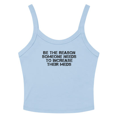 "Be the reason someone needs to increase their meds" printed on a solid baby blue blend women's micro-rib tanktop laying on a flat surface amongst sunglasses and shorts