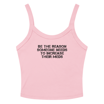 "Be the reason someone needs to increase their meds" printed on a solid pink blend women's micro-rib tanktop laying on a flat surface amongst sunglasses and shorts