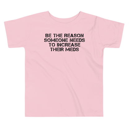 "Be the reason someone needs to increase their meds" printed on a pink toddler short sleeve tee laying on a flat surface