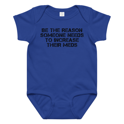 "Be the reason someone needs to increase their meds" printed on a royal baby jersey bodysuit laying on a flat surface amongst other clothes