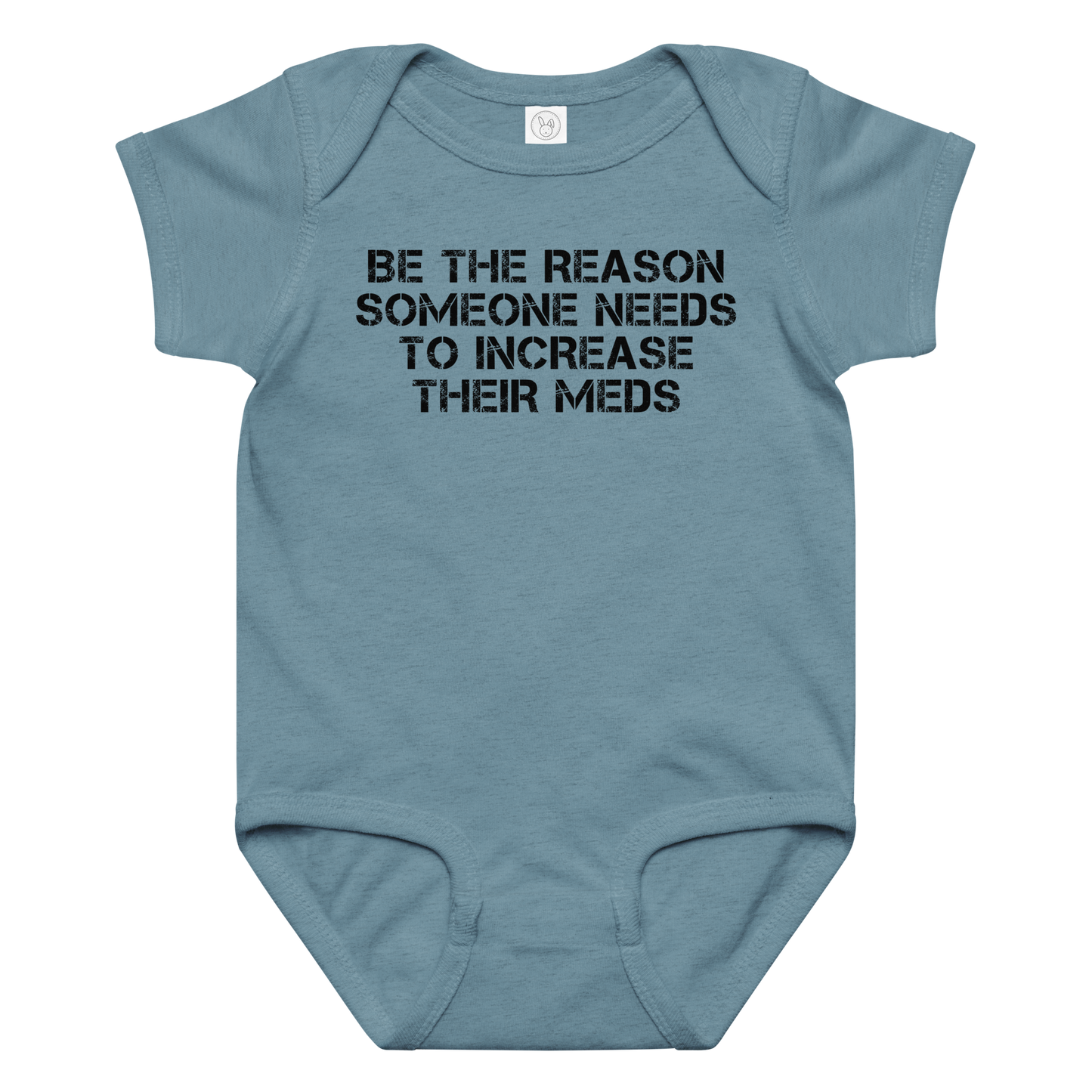 "Be the reason someone needs to increase their meds" printed on a vintage indigo baby jersey bodysuit laying on a flat surface amongst other clothes