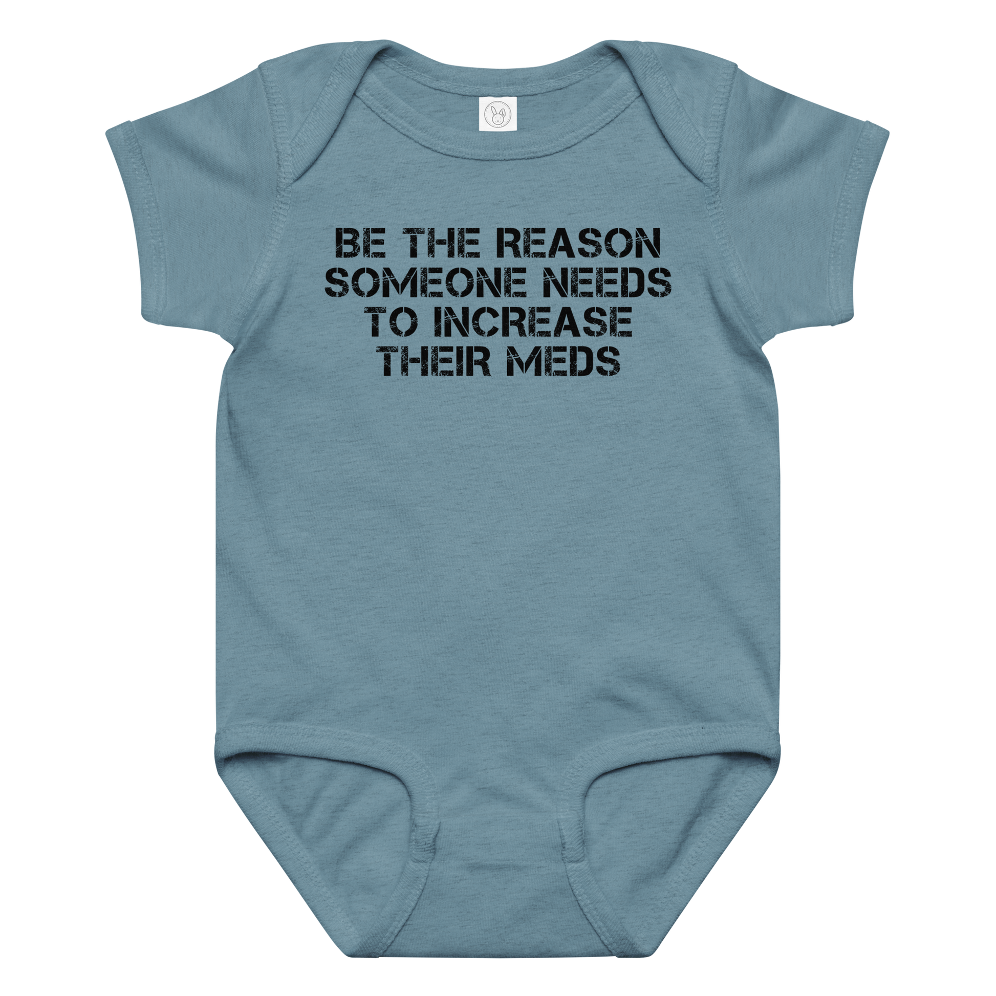 "Be the reason someone needs to increase their meds" printed on a vintage indigo baby jersey bodysuit laying on a flat surface amongst other clothes
