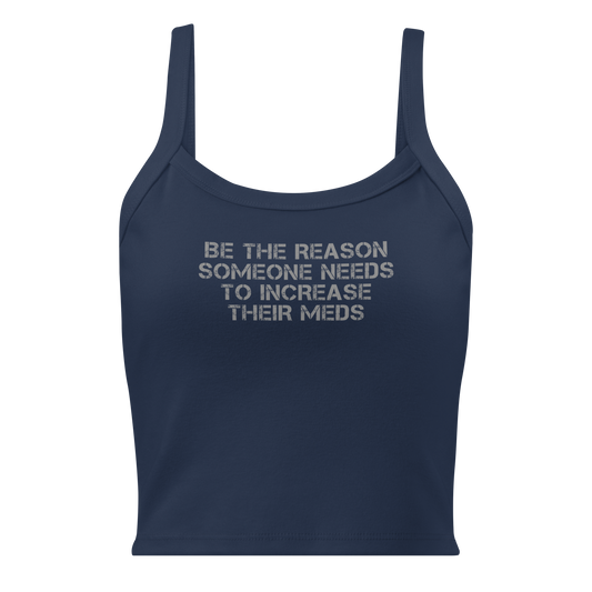 "Be the reason someone needs to increase their meds" printed on a solid navy blend women's micro-rib tanktop laying on a flat surface