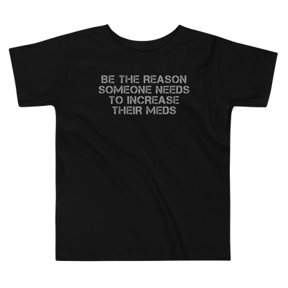"Be the reason someone needs to increase their meds" printed on a black toddler short sleeve tee laying on a flat surface