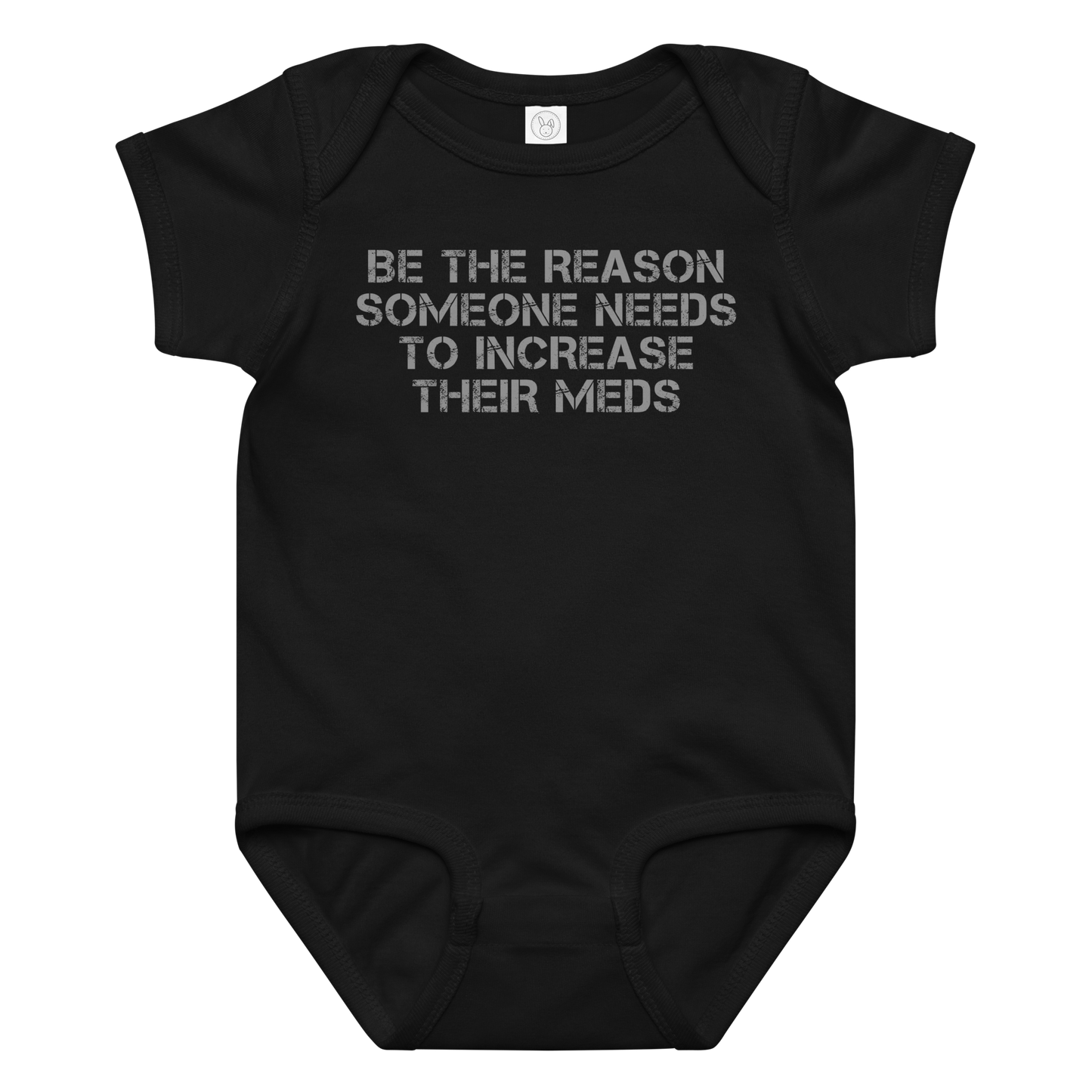 "Be the reason someone needs to increase their meds" printed on a black baby jersey bodysuit laying on a flat surface amongst other clothes