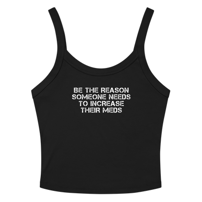 "Be the reason someone needs to increase their meds" printed on a solid black blend women's micro-rib tanktop laying on a flat surface amongst sunglasses and shorts