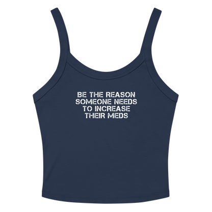 "Be the reason someone needs to increase their meds" printed on a solid navy blend women's micro-rib tanktop laying on a flat surface amongst sunglasses and shorts