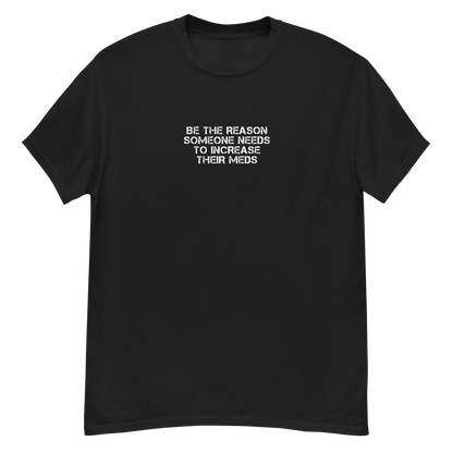 "Be the reason someone needs to increase their meds" printed on a black unisex classic tee laying on a flat surface