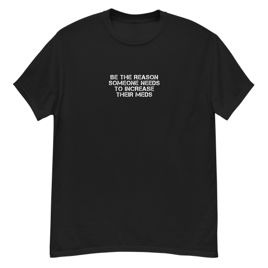 "Be the reason someone needs to increase their meds" printed on a black unisex classic tee laying on a flat surface