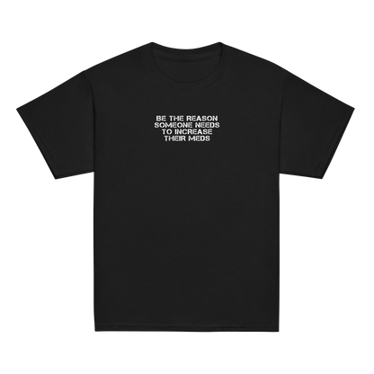 "Be the reason someone needs to increase their meds" printed on a black youth classic tee laying on a flat surface