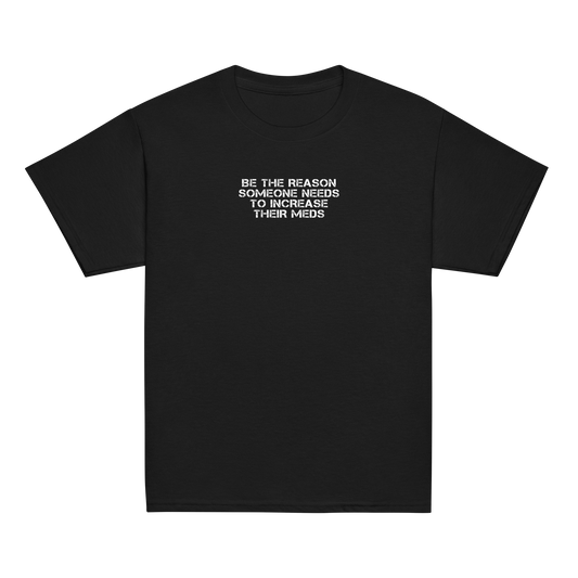 "Be the reason someone needs to increase their meds" printed on a black youth classic tee laying on a flat surface