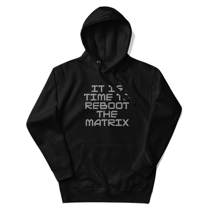 "It's time to reboot the matrix" printed on a black unisex hoodie laying on a flat surface with the hood up