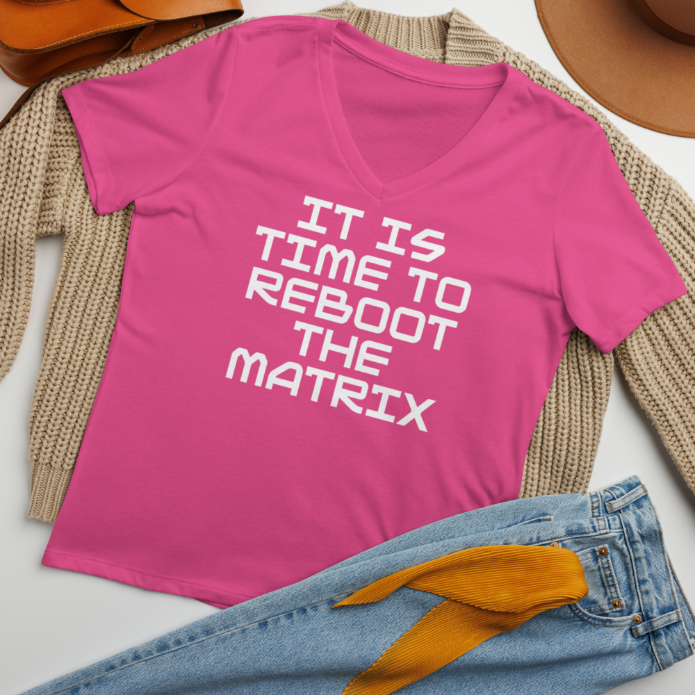 "It's time to reboot the matrix" printed on a berry women's relaxed v-neck t-shirt laying on a flat surface amongst other clothes