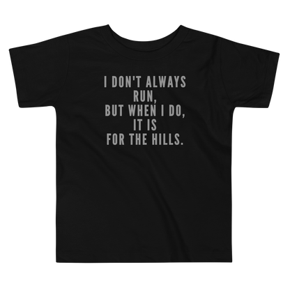 "I don't always run, but when I do, it is for the hills." printed on a black toddler short sleeve tee laying on a flat surface