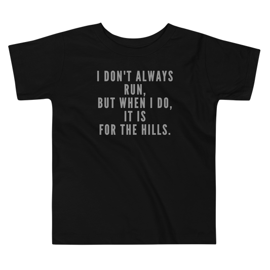 "I don't always run, but when I do, it is for the hills." printed on a black toddler short sleeve tee laying on a flat surface