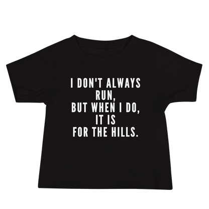 "I don't always run, but when I do, it is for the hills." printed on a black baby jersey short sleeve tee laying on a flat surface