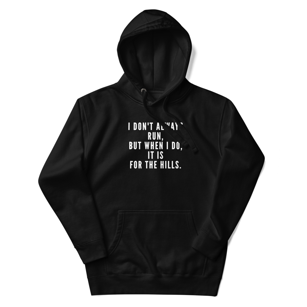 "I don't always run, but when I do, it is for the hills." printed on a black unisex hoodie laying on a flat surface with the hood up