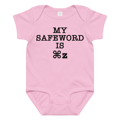 "My Safe Word Is ⌘Z" printed on a pink baby jersey bodysuit laying on a flat surface amongst other clothes