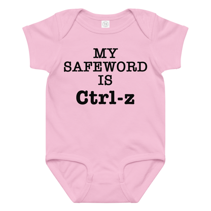 "My Safe Word Is Ctrl-Z" printed on a pink baby jersey bodysuit laying on a flat surface amongst other clothes