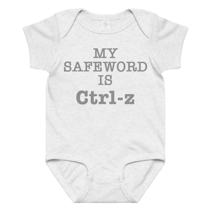 "My Safe Word Is Ctrl-Z" printed on a ash baby jersey bodysuit laying on a flat surface amongst other clothes