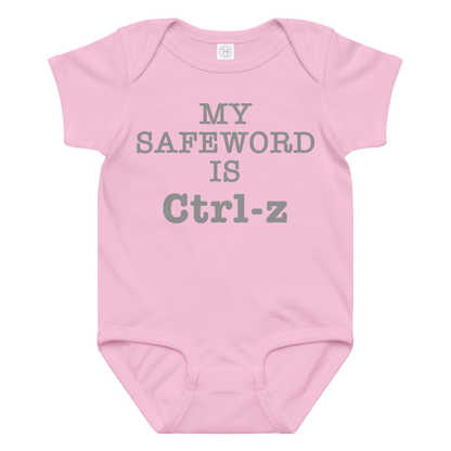 "My Safe Word Is Ctrl-Z" printed on a pink baby jersey bodysuit laying on a flat surface amongst other clothes