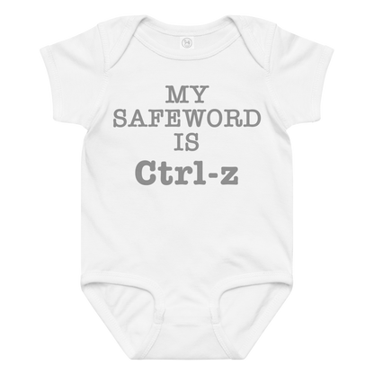 "My Safe Word Is Ctrl-Z" printed on a white baby jersey bodysuit laying on a flat surface amongst other clothes