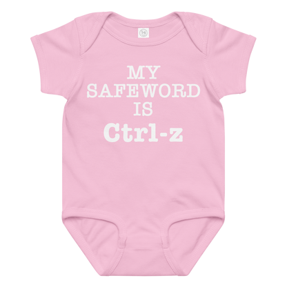 "My Safe Word Is Ctrl-Z" printed on a pink baby jersey bodysuit laying on a flat surface amongst other clothes