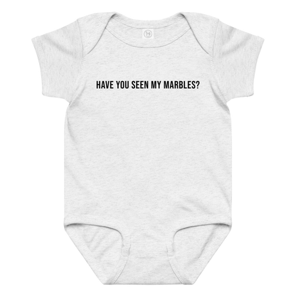 "Have you seen my marbles?" printed on a ash baby jersey bodysuit laying on a flat surface amongst other clothes