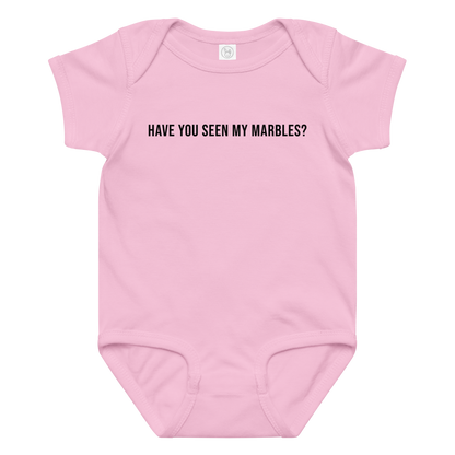 "Have you seen my marbles?" printed on a pink baby jersey bodysuit laying on a flat surface amongst other clothes