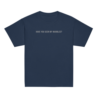 "Have you seen my marbles?" printed on a navy youth classic tee laying on a flat surface