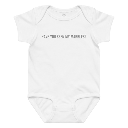 "Have you seen my marbles?" printed on a white baby jersey bodysuit laying on a flat surface amongst other clothes