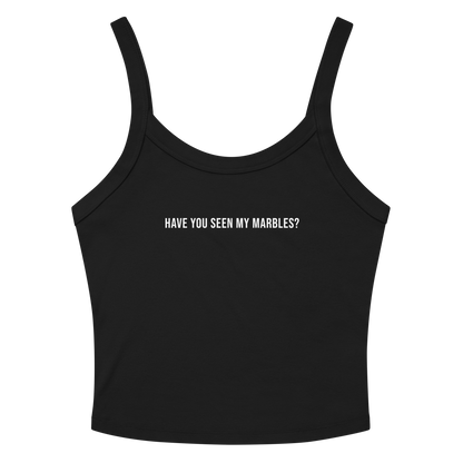 "Have you seen my marbles?" printed on a solid black blend women's micro-rib tanktop laying on a flat surface amongst sunglasses and shorts