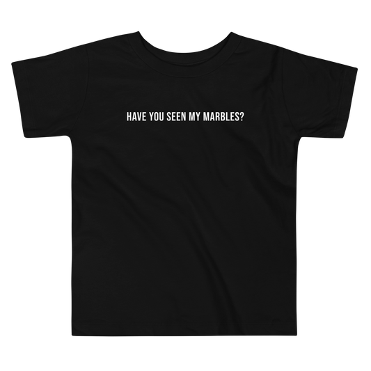 "Have you seen my marbles?" printed on a black toddler short sleeve tee laying on a flat surface