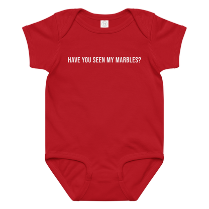 "Have you seen my marbles?" printed on a red baby jersey bodysuit laying on a flat surface amongst other clothes