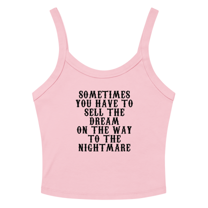 "Sometimes you have to sell the dream on the way to the nightmare" printed on a solid pink blend women's micro-rib tanktop laying on a flat surface amongst sunglasses and shorts