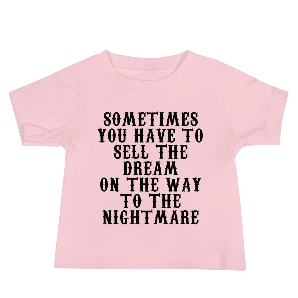 "Sometimes you have to sell the dream on the way to the nightmare" printed on a pink baby jersey short sleeve tee laying on a flat surface