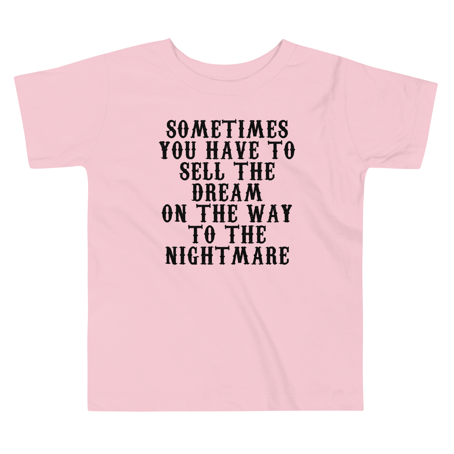 "Sometimes you have to sell the dream on the way to the nightmare" printed on a pink toddler short sleeve tee laying on a flat surface