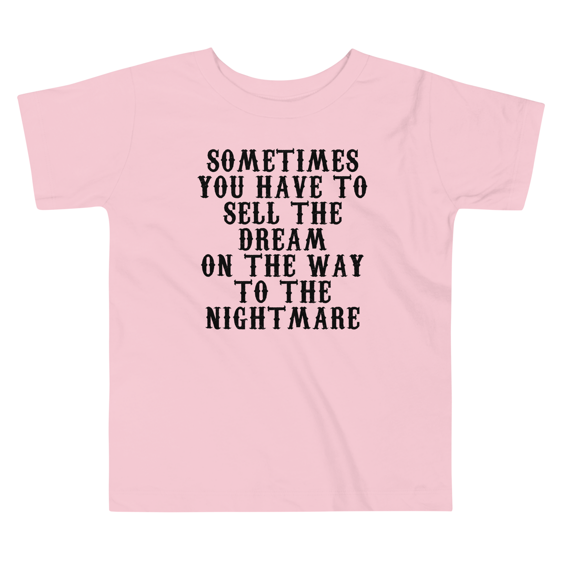 "Sometimes you have to sell the dream on the way to the nightmare" printed on a pink toddler short sleeve tee laying on a flat surface