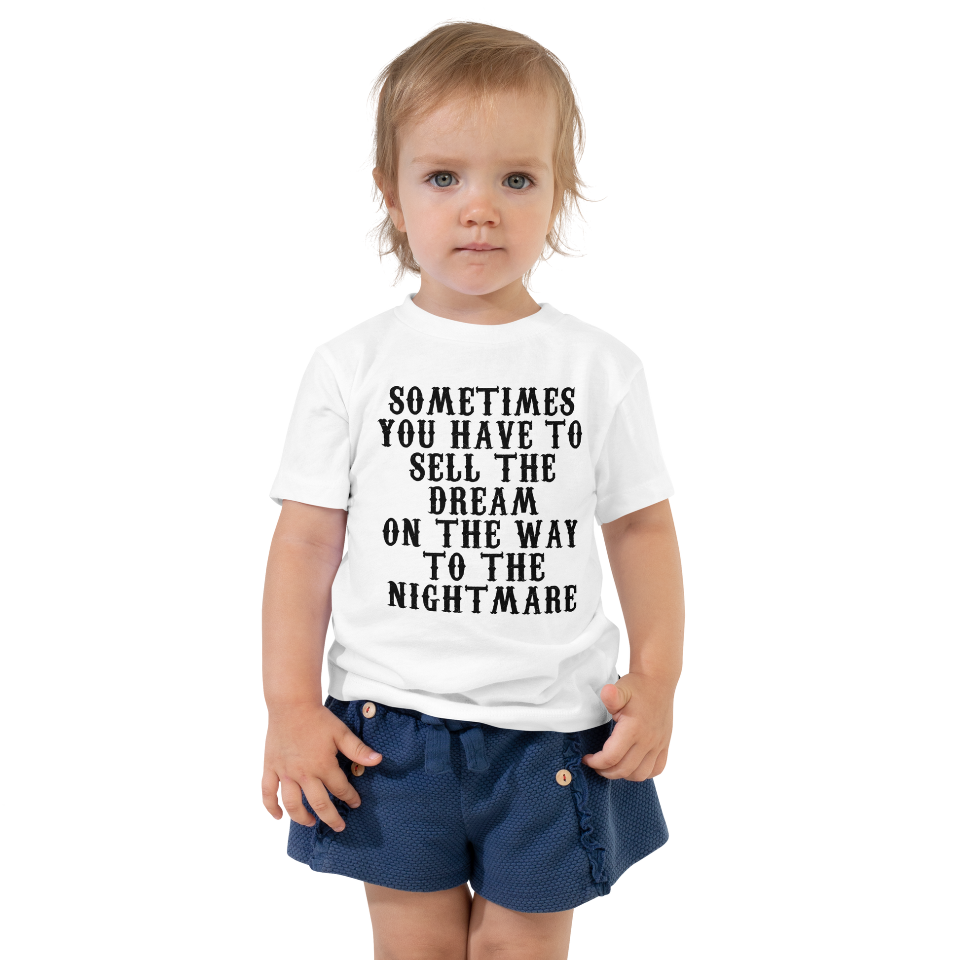 "Sometimes you have to sell the dream on the way to the nightmare" printed on a white toddler short sleeve tee worn by a female