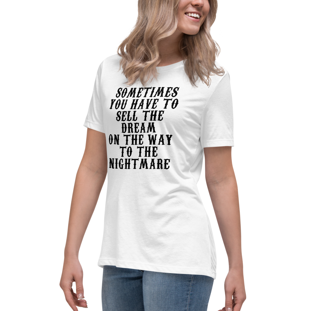 "Sometimes you have to sell the dream on the way to the nightmare" printed on a white women's relaxed t-shirt worn by a female