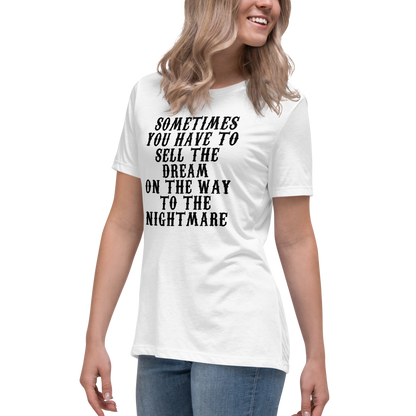 "Sometimes you have to sell the dream on the way to the nightmare" printed on a white women's relaxed t-shirt worn by a female