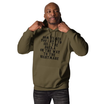 "Sometimes you have to sell the dream on the way to the nightmare" printed on a military green unisex hoodie worn by a male