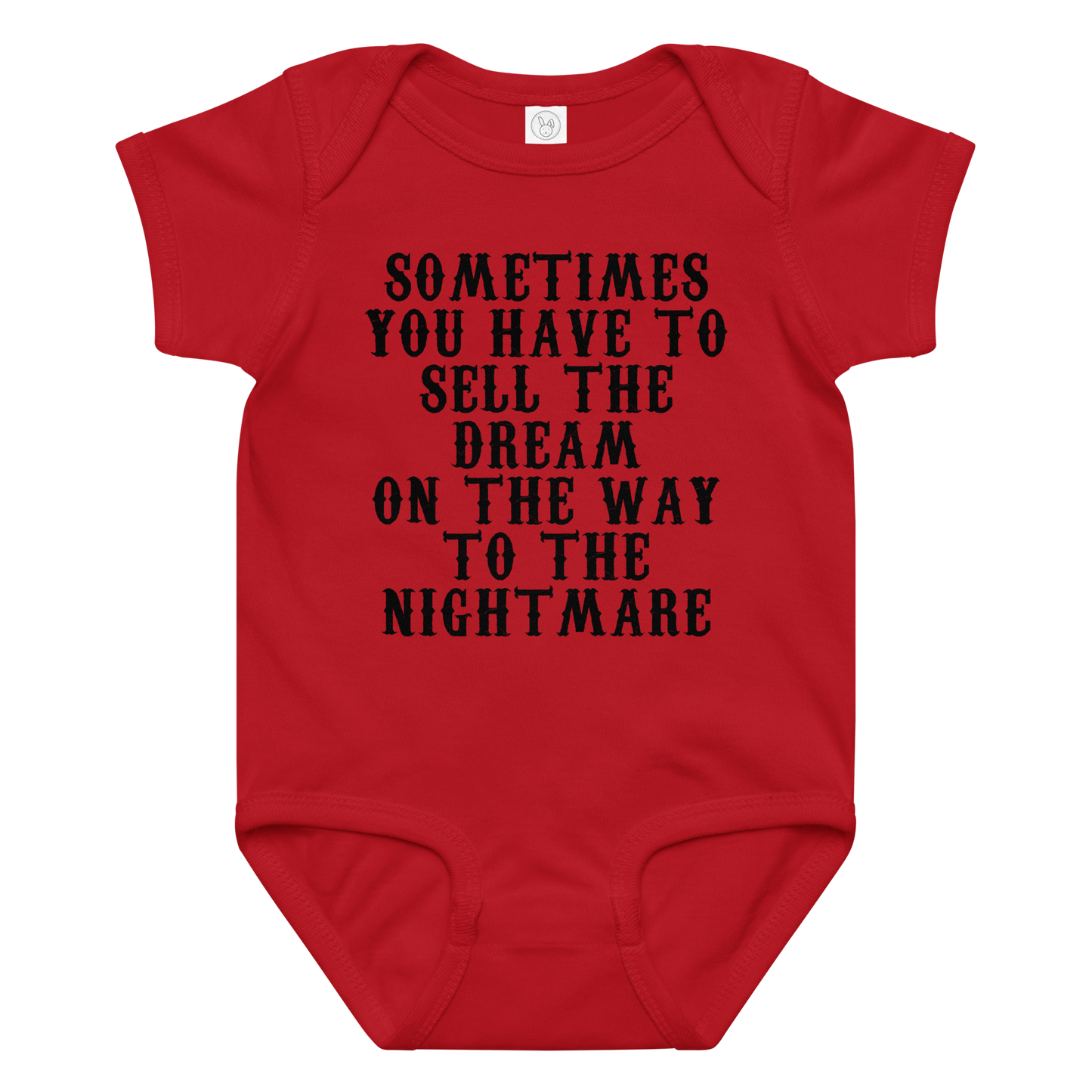 "Sometimes you have to sell the dream on the way to the nightmare" printed on a red baby jersey bodysuit laying on a flat surface amongst other clothes