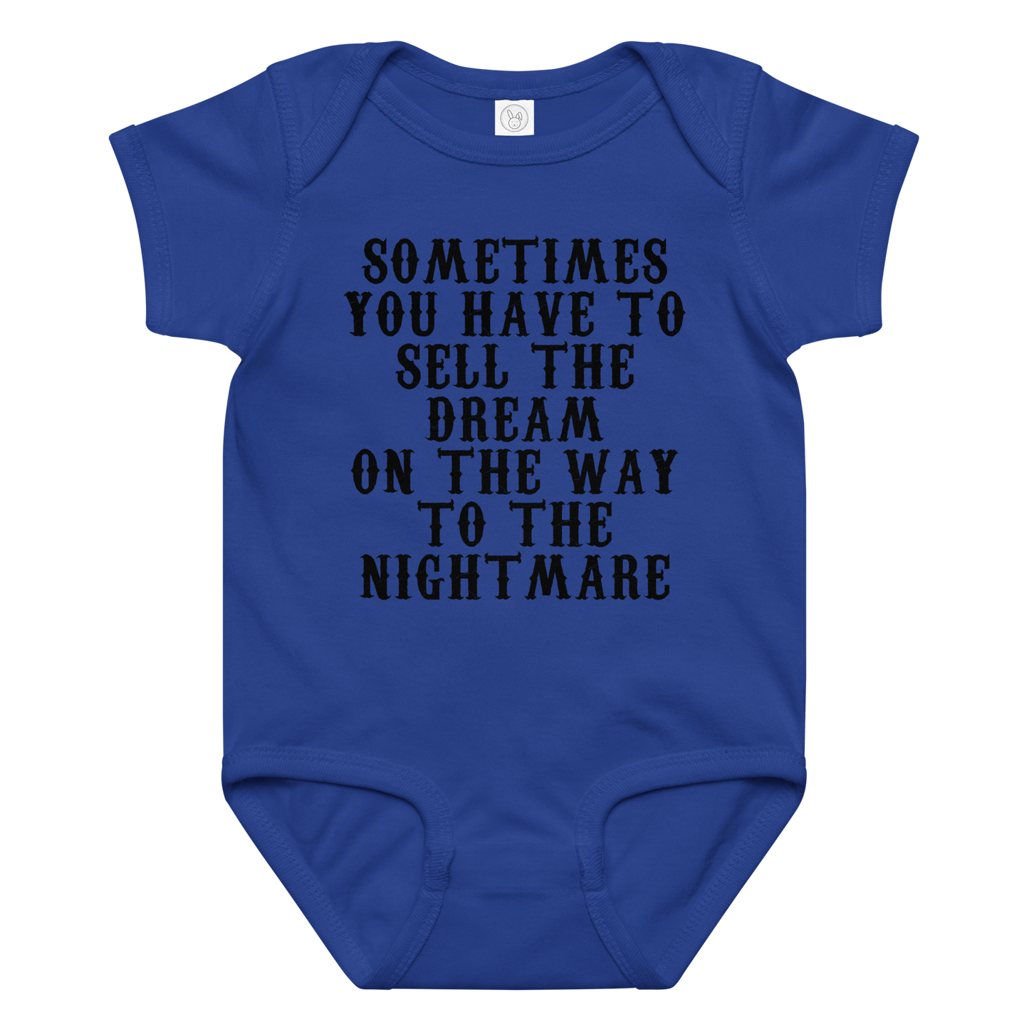 "Sometimes you have to sell the dream on the way to the nightmare" printed on a royal baby jersey bodysuit laying on a flat surface amongst other clothes