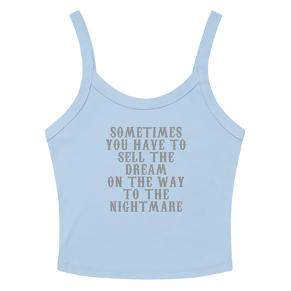 "Sometimes you have to sell the dream on the way to the nightmare" printed on a solid baby blue blend women's micro-rib tanktop laying on a flat surface amongst sunglasses and shorts