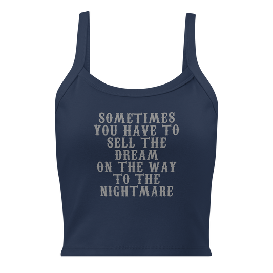"Sometimes you have to sell the dream on the way to the nightmare" printed on a solid navy blend women's micro-rib tanktop laying on a flat surface