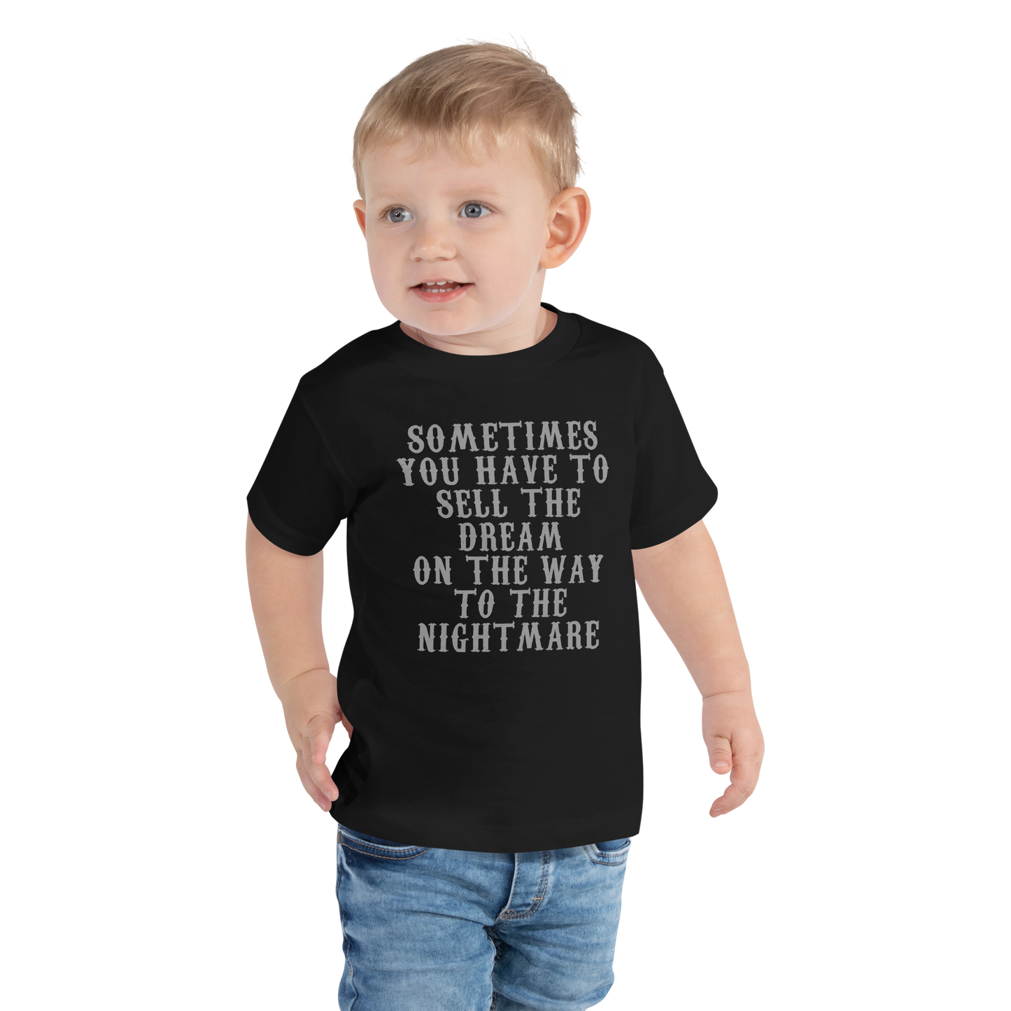 "Sometimes you have to sell the dream on the way to the nightmare" printed on a black toddler short sleeve tee worn by a male