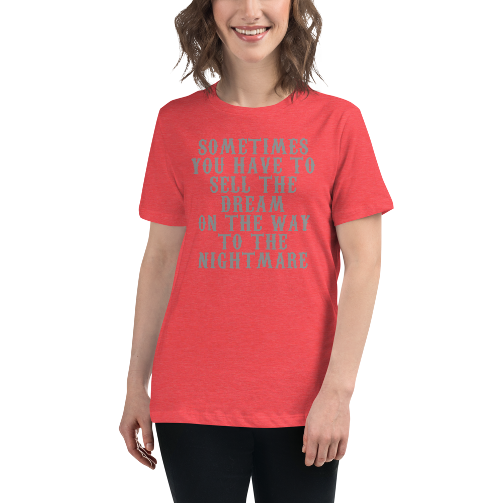 "Sometimes you have to sell the dream on the way to the nightmare" printed on a heather red women's relaxed t-shirt worn by a female