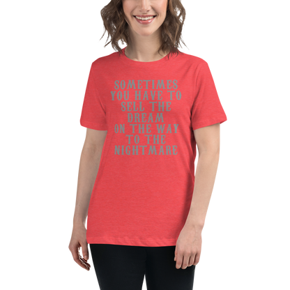 "Sometimes you have to sell the dream on the way to the nightmare" printed on a heather red women's relaxed t-shirt worn by a female
